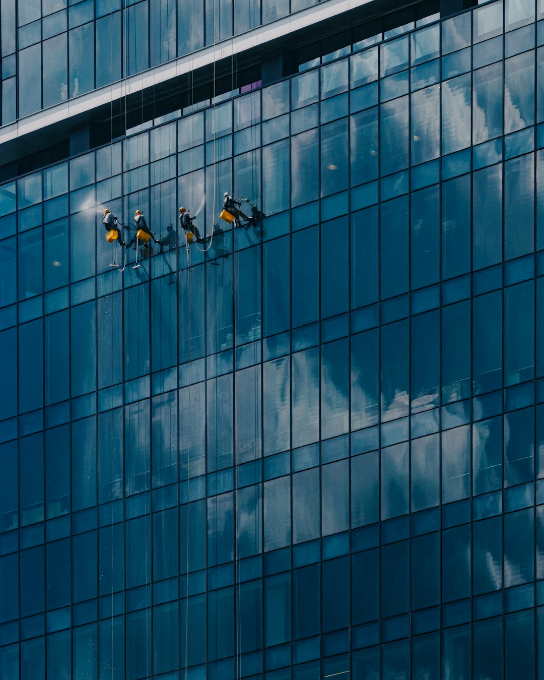 Window washers cleaning the glass windows of TRX tower in Malaysia